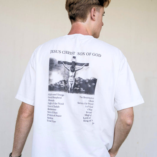 Angled back view of white Christian t-shirt featuring “Jesus Christ Son of God” crucifixion graphic and scripture list.