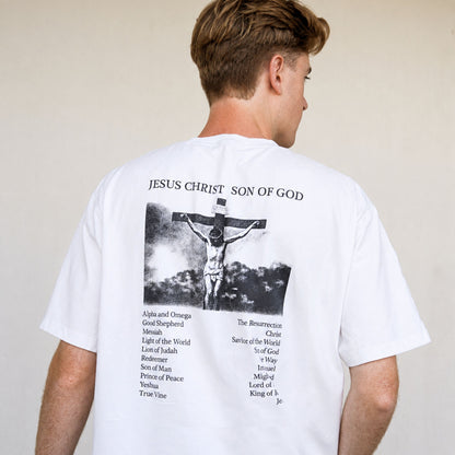 Person wearing a white t-shirt with a graphic and text on the back, standing against a plain background.