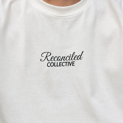 White t-shirt with 'Reconciled Collective' text on a plain background
